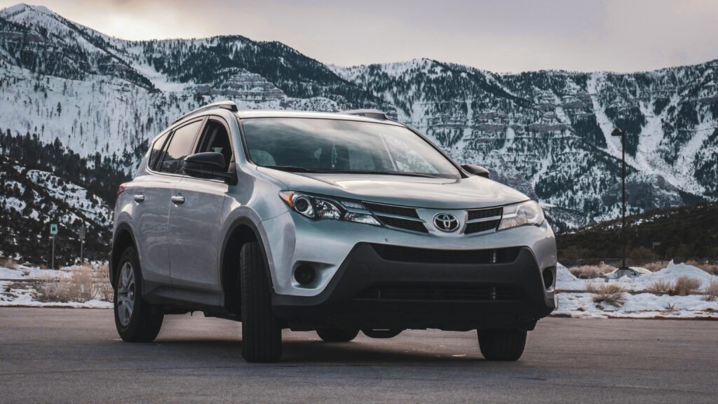 pexels photo 2036544 2036544 A silver SUV is parked in front of stunning snow-covered mountains during daytime.
